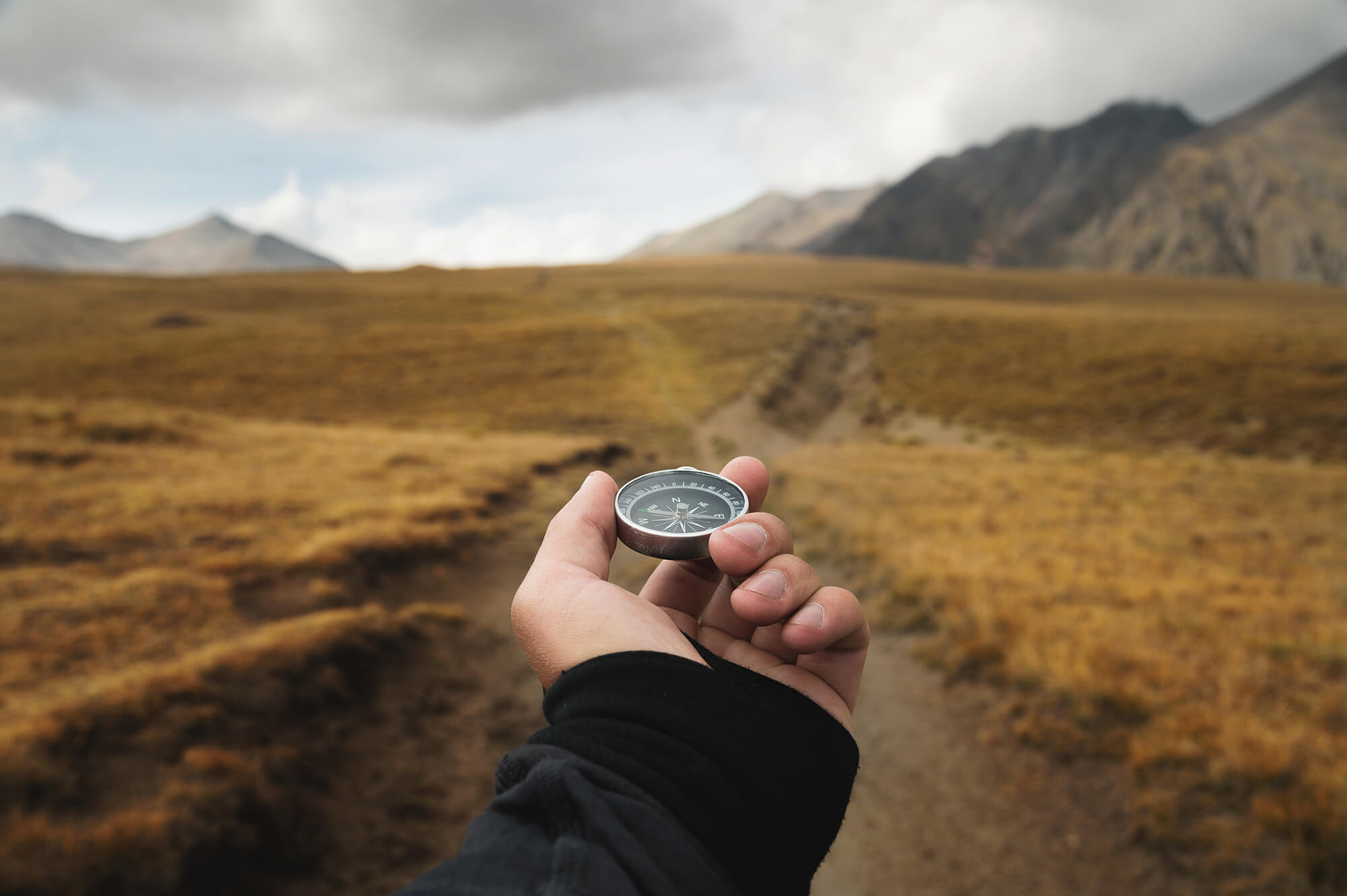 Man's hand holding a magnetic compass